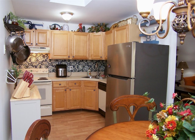 kitchen featuring white appliances, light wood-type flooring, light brown cabinetry, sink, and tasteful backsplash