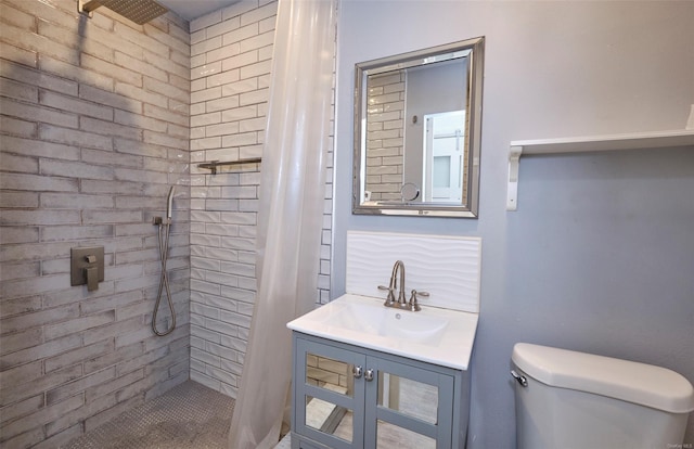 bathroom featuring vanity, toilet, and tiled shower
