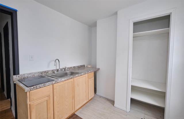 bar featuring black electric stovetop and a sink