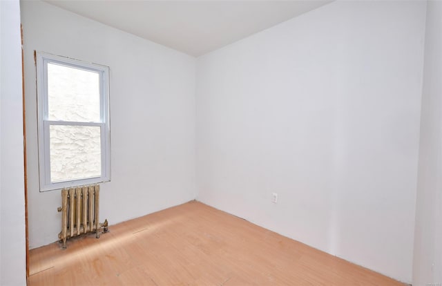 empty room with radiator and wood finished floors