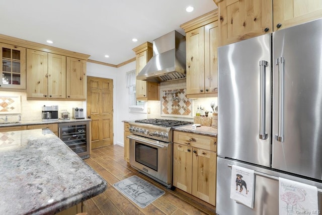 kitchen featuring wall chimney exhaust hood, wine cooler, high quality appliances, glass insert cabinets, and light stone counters