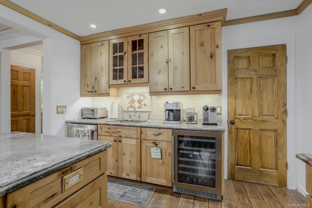 kitchen featuring wine cooler, dark wood-style flooring, a sink, glass insert cabinets, and crown molding