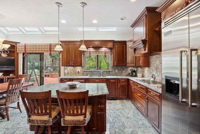 kitchen with a sink, stainless steel built in refrigerator, a center island, and decorative backsplash