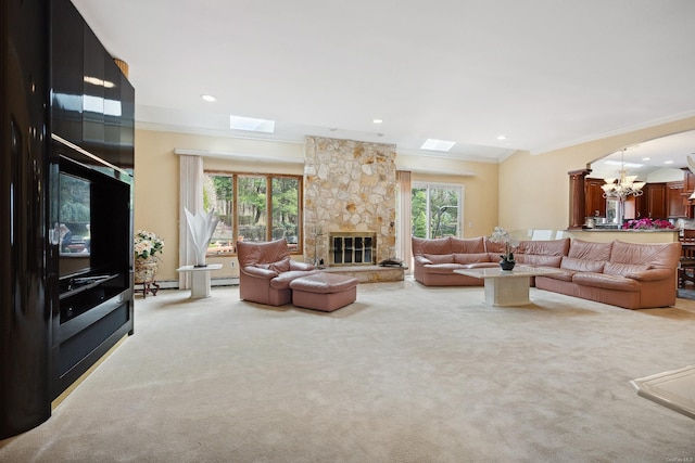 living room with crown molding, a stone fireplace, a chandelier, and a skylight