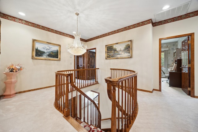 hall featuring visible vents, an upstairs landing, an inviting chandelier, and light carpet