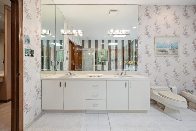 full bathroom featuring a sink, a bidet, and wallpapered walls