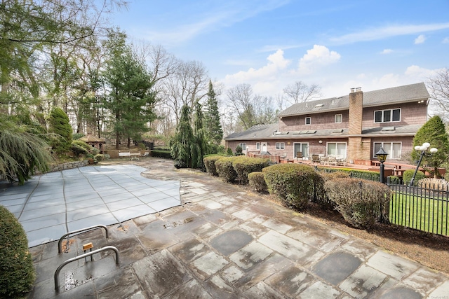 exterior space featuring a wooden deck, a patio area, and fence