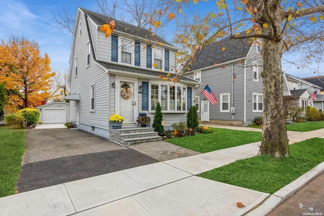 view of front of house featuring an outbuilding, a front yard, and a garage