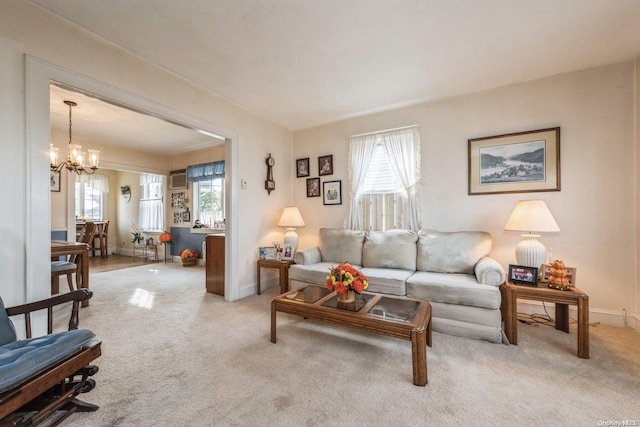 carpeted living room featuring a wealth of natural light and an inviting chandelier