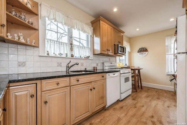 kitchen with backsplash, a wealth of natural light, sink, white appliances, and light wood-type flooring