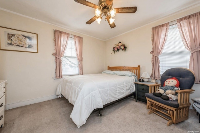 bedroom with ceiling fan, crown molding, and light carpet