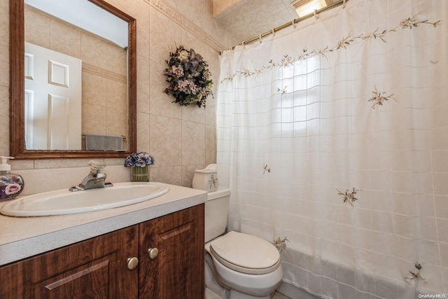 bathroom with toilet, tile walls, vanity, and curtained shower