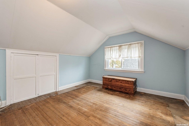 additional living space featuring lofted ceiling and light hardwood / wood-style floors