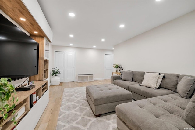 living room with baseboards, light wood-type flooring, and recessed lighting