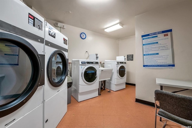 community laundry room featuring baseboards and washing machine and clothes dryer