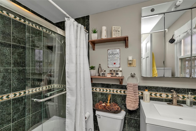 bathroom with vanity, curtained shower, toilet, and tile walls