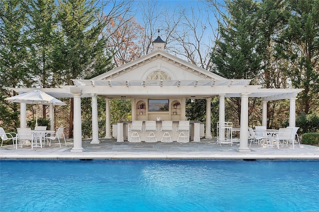 view of pool featuring a pergola, exterior bar, and a patio