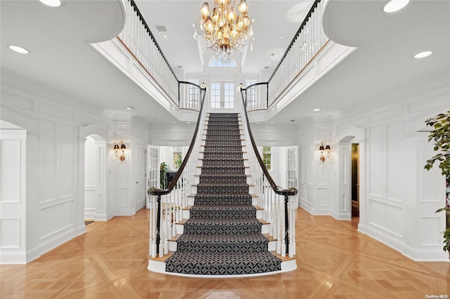 stairs with parquet flooring and ornamental molding