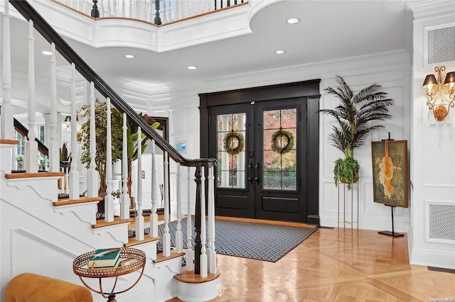 entrance foyer with parquet flooring, crown molding, and french doors