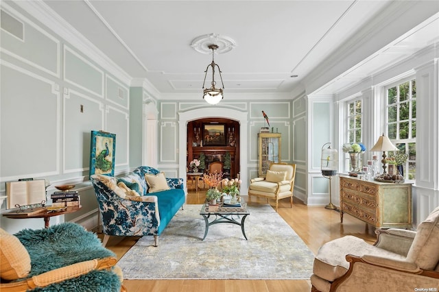 sitting room with wood-type flooring and ornamental molding