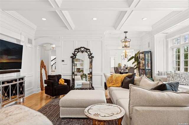 living room with hardwood / wood-style floors, beamed ceiling, a chandelier, and coffered ceiling