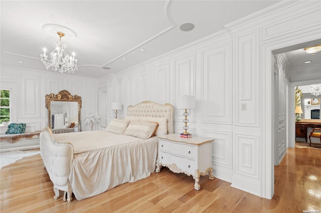 bedroom featuring light hardwood / wood-style floors, an inviting chandelier, and crown molding