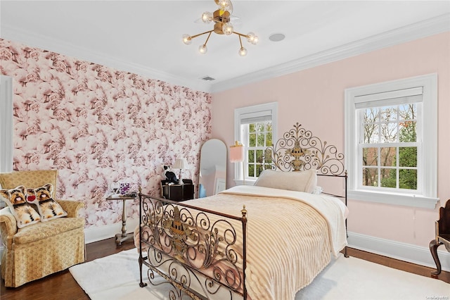 bedroom featuring dark hardwood / wood-style floors, ornamental molding, and an inviting chandelier