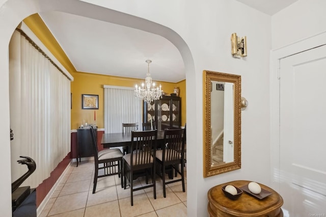 tiled dining space featuring a notable chandelier