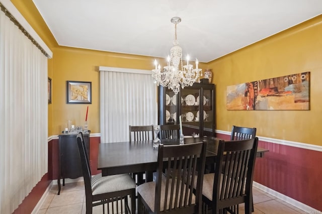 tiled dining room with an inviting chandelier