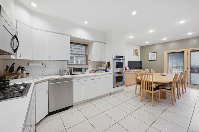 kitchen featuring white cabinets, light tile patterned floors, and appliances with stainless steel finishes