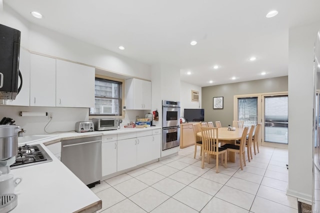 kitchen featuring white cabinets, stainless steel appliances, and light tile patterned floors