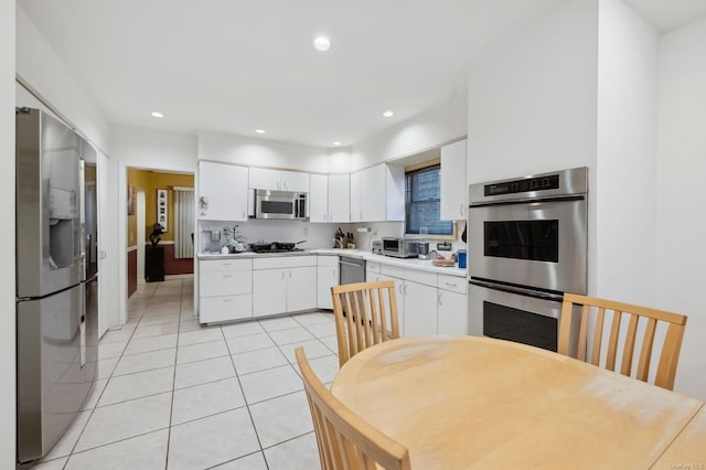 kitchen with white cabinets, appliances with stainless steel finishes, and light tile patterned floors