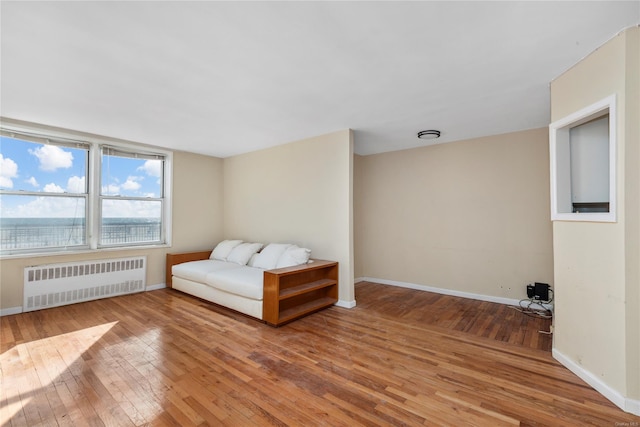 unfurnished room featuring hardwood / wood-style floors and radiator