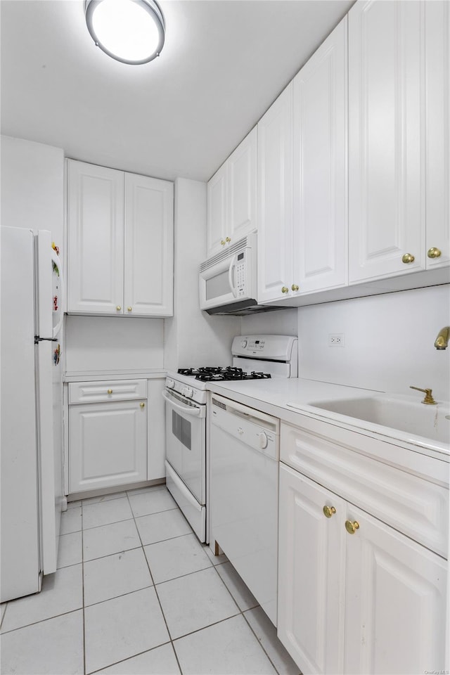 kitchen featuring white cabinets, white appliances, sink, and light tile patterned floors