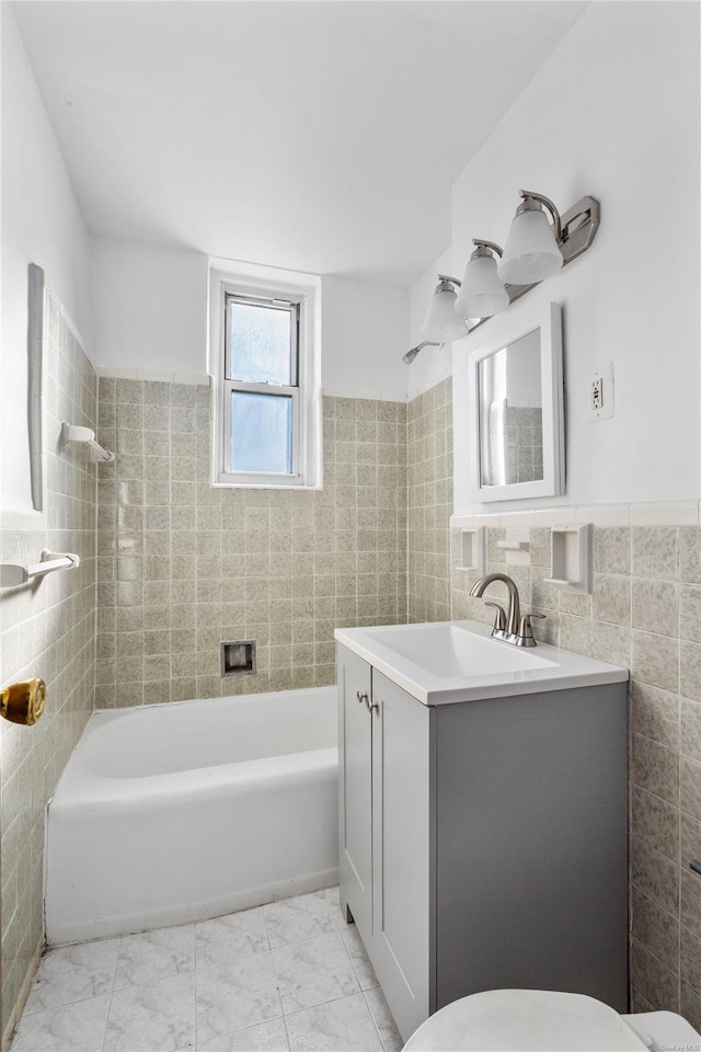 full bathroom with vanity, tiled shower / bath combo, tile walls, and toilet