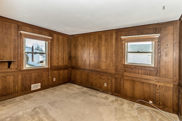 carpeted spare room with wood walls