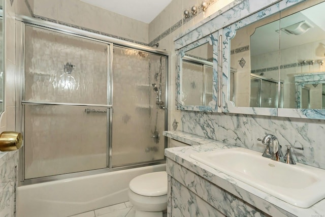 full bathroom featuring tile walls, backsplash, shower / bath combination with glass door, and toilet