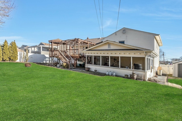 rear view of property with a yard, a pergola, and a sunroom