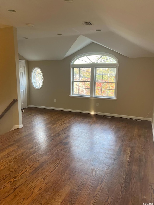 42-04 216th St, Bayside, NY 11361 - unfurnished room featuring visible vents, baseboards, vaulted ceiling, and dark wood finished floors