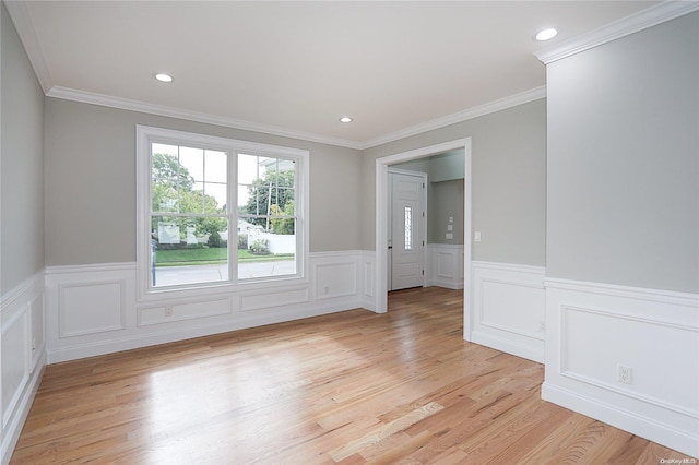 spare room with light hardwood / wood-style floors and crown molding