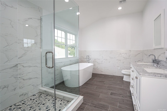 full bathroom featuring vanity, separate shower and tub, toilet, and tile walls