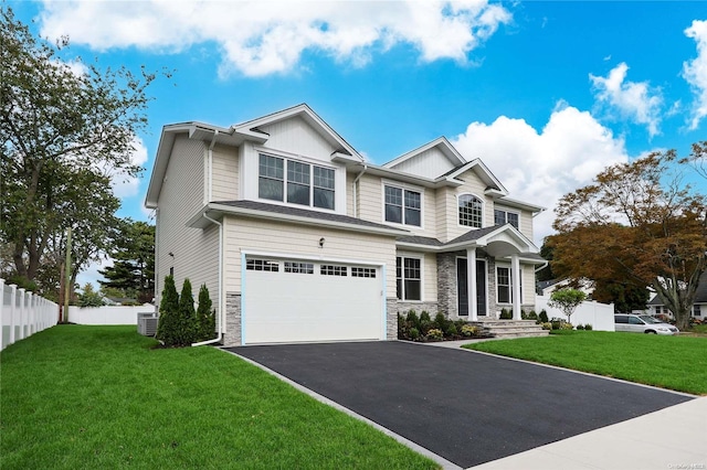 craftsman inspired home featuring a garage and a front lawn