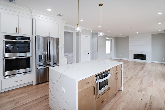 kitchen featuring stainless steel appliances, light wood-type flooring, visible vents, and crown molding