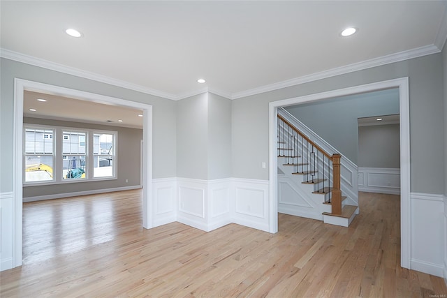 spare room featuring recessed lighting, light wood-style floors, stairs, wainscoting, and crown molding