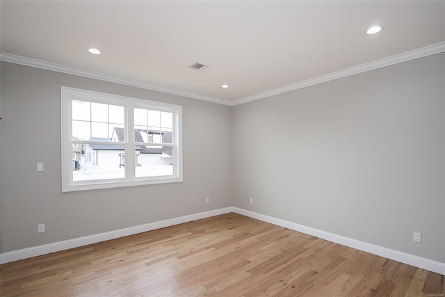 unfurnished room with ornamental molding, light wood-type flooring, and baseboards