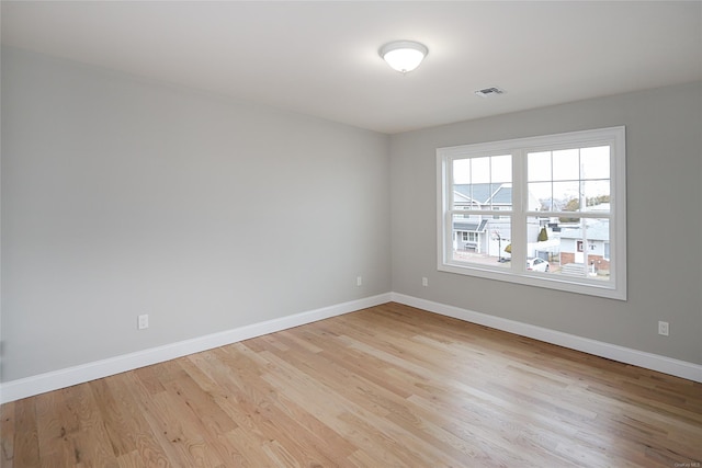 unfurnished room featuring light wood-style floors, baseboards, and visible vents