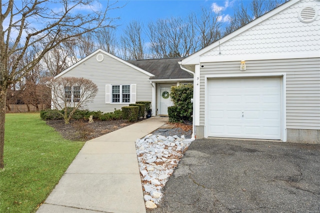 single story home with an attached garage, driveway, and a front lawn