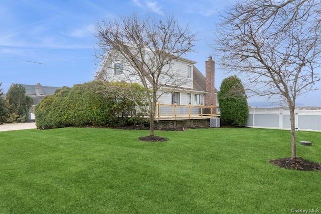 view of front of property with central air condition unit, a wooden deck, and a front lawn