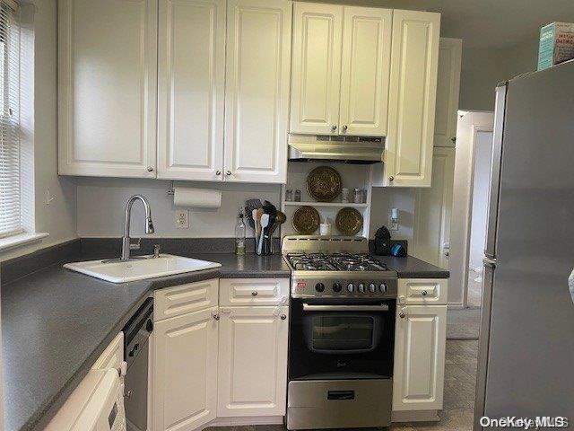 kitchen with appliances with stainless steel finishes, white cabinetry, and sink