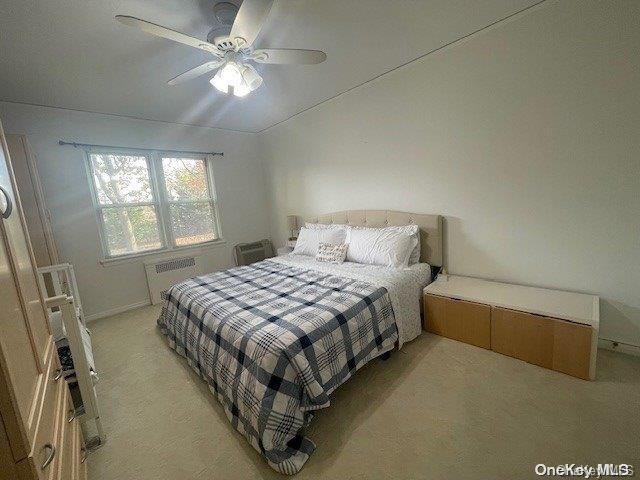 bedroom with light carpet, vaulted ceiling, and ceiling fan